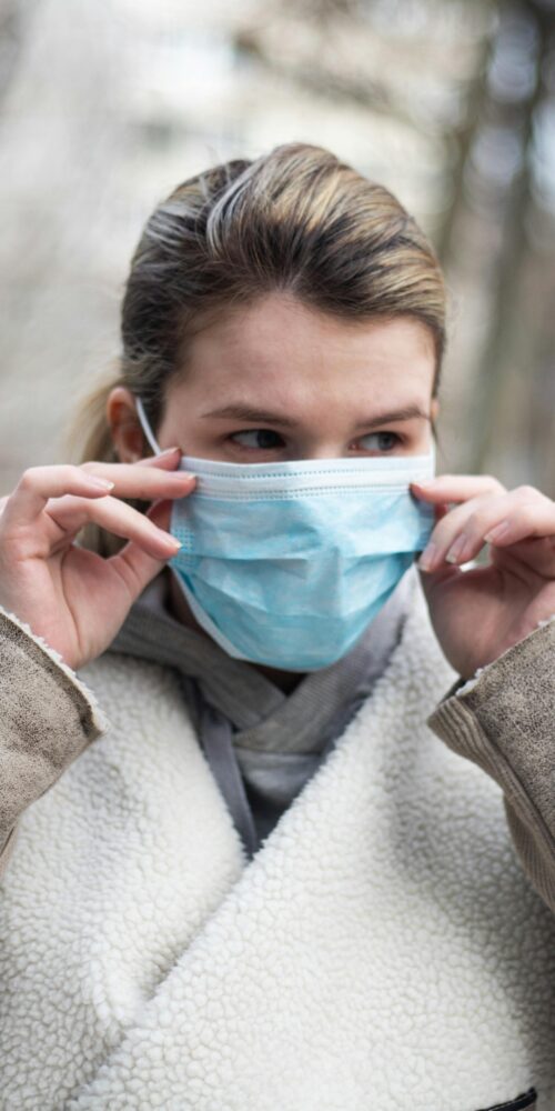 Woman wearing a mask in public to protect against illness.