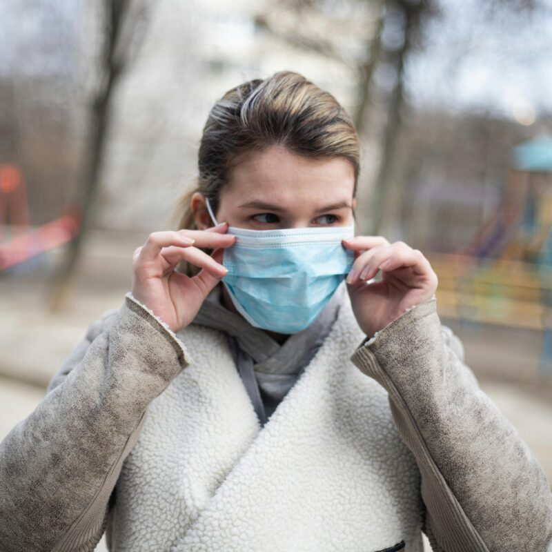 Woman wearing a mask in public to protect against illness.