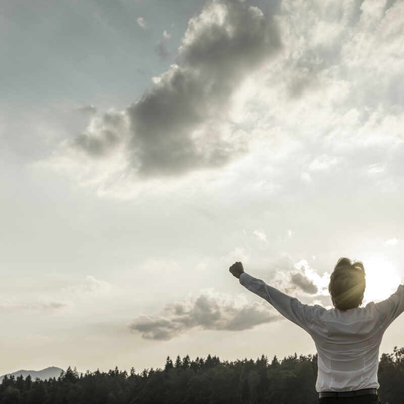 Woman raising proud arms to the sun.