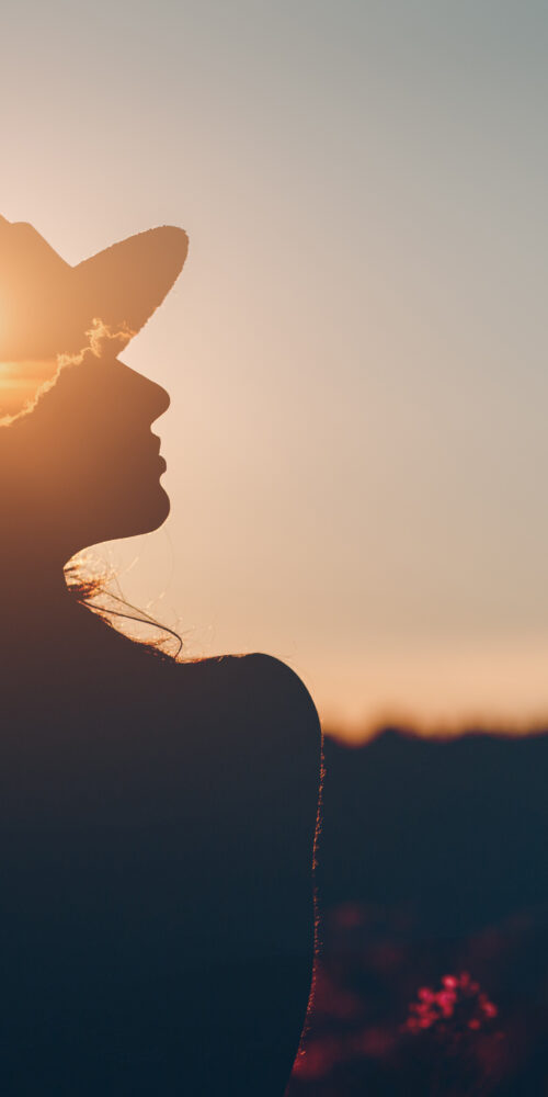 Silhouette of woman outside breathing sigh of relief.