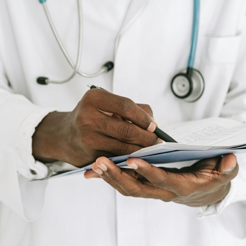Doctor writing on a notepad.