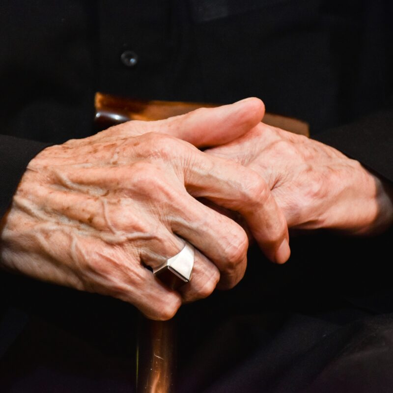 Can physical therapy help arthritis? An older gentleman's arthritic hands holding a cane